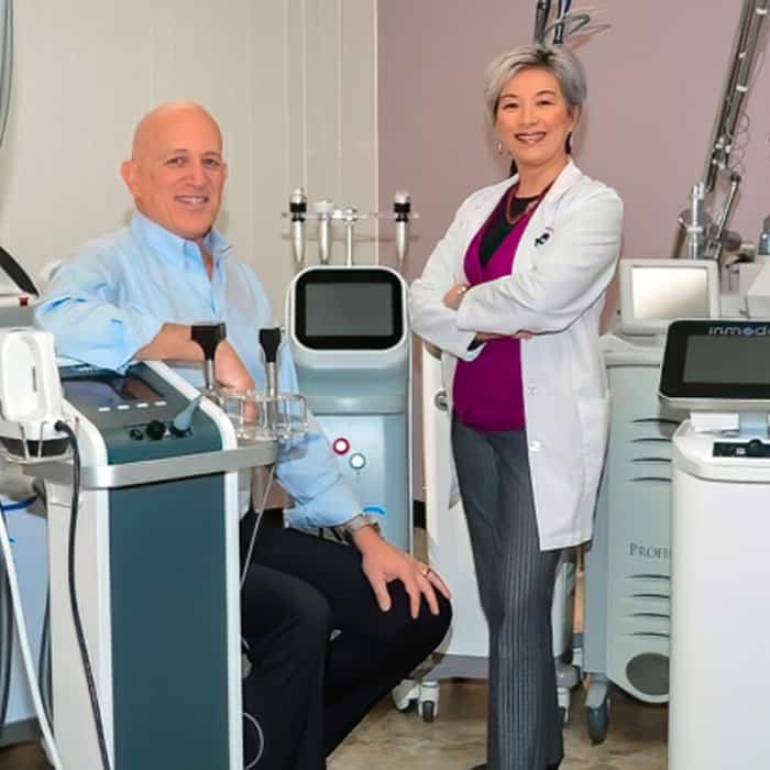 mobile-header-30-plus-lasers Dr. Asher Milgrom and Dr. Alice Pien with their forest of 30 cosmetic lasers.